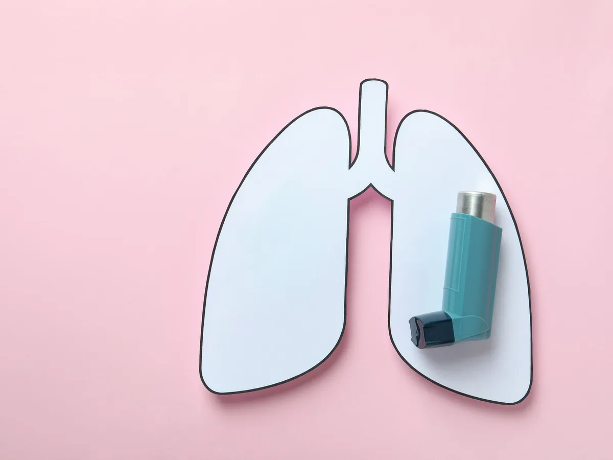 Pembe zeminde kâğıttan akciğer şekli ve üzerinde inhaler